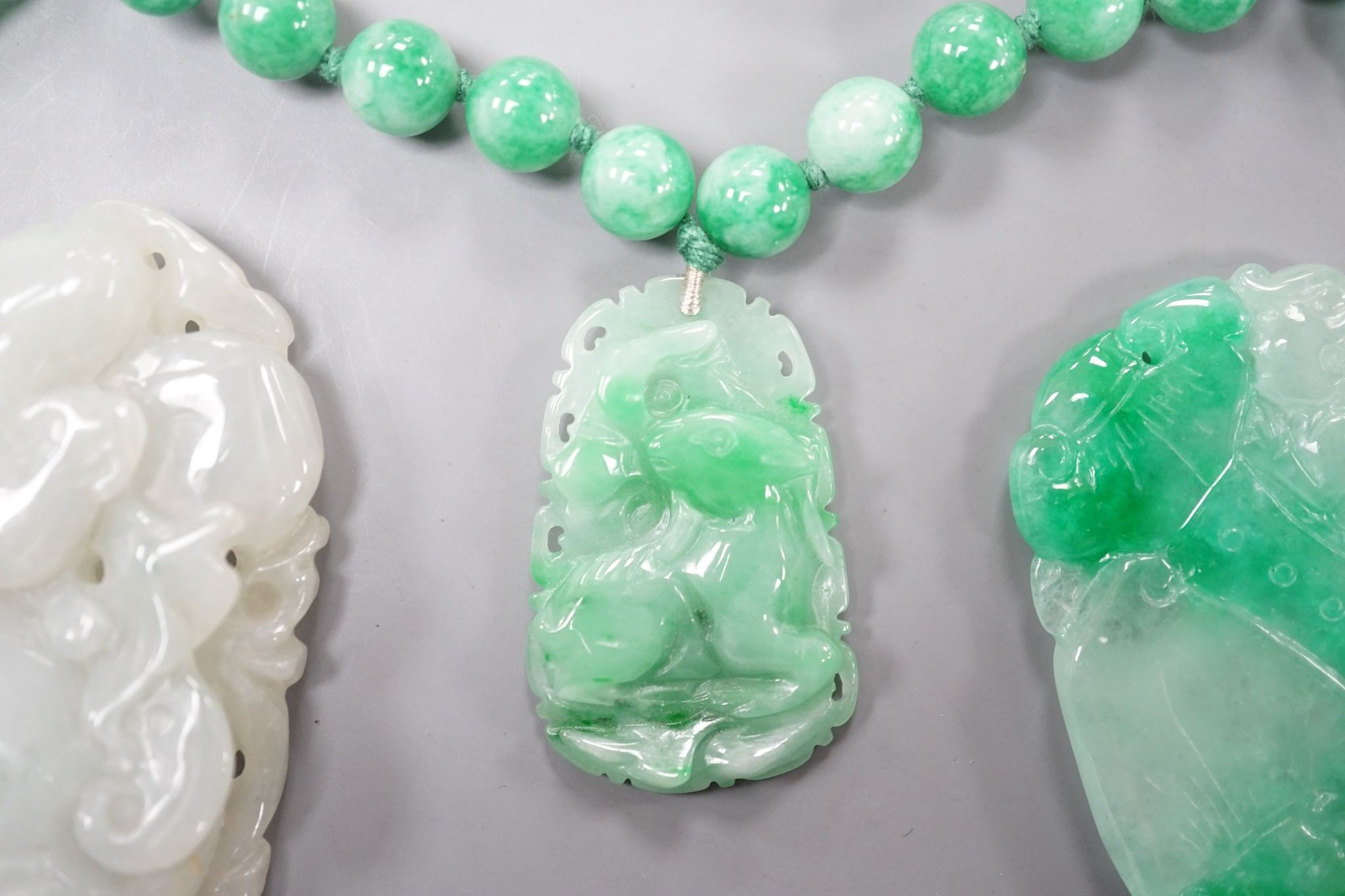 A jade bead necklace hung with three jade carvings, 49cm and three other jade carvings.